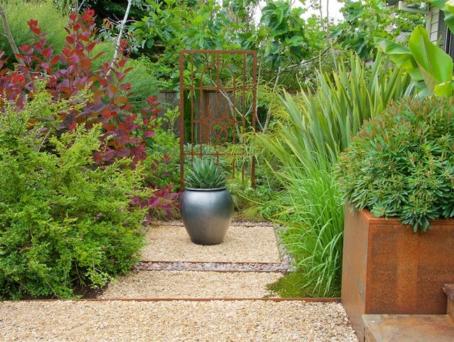 Silver urn planter used as focal point in modern garden