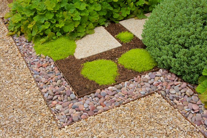 Smooth river rock, compacted granite and square pavers showing hardscape textural variety
