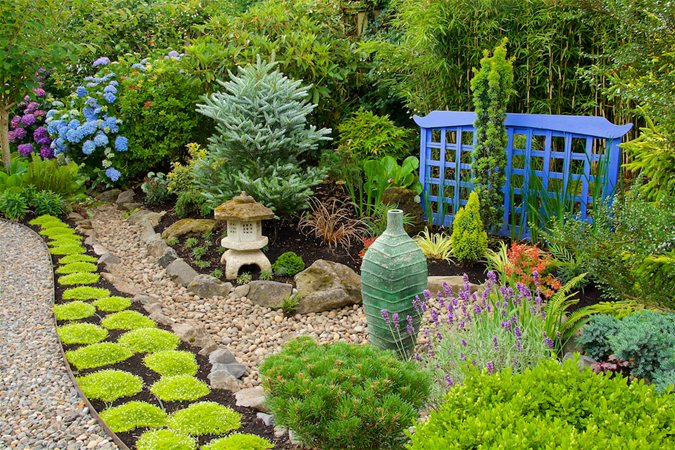 Elements of hardscape, plants, structures and statuary providing a wide array of textures in a captivating garden scene